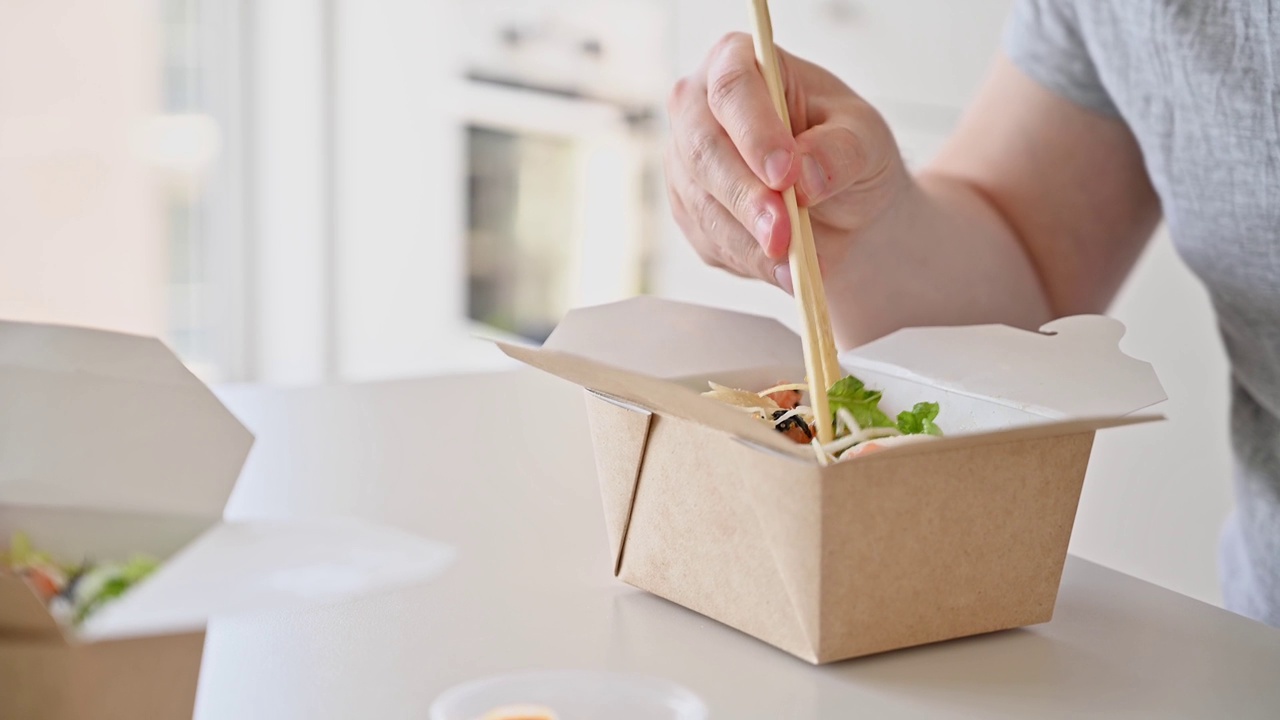 传统夏威夷美食外卖戳碗。食品交付。男子在家里吃戳碗