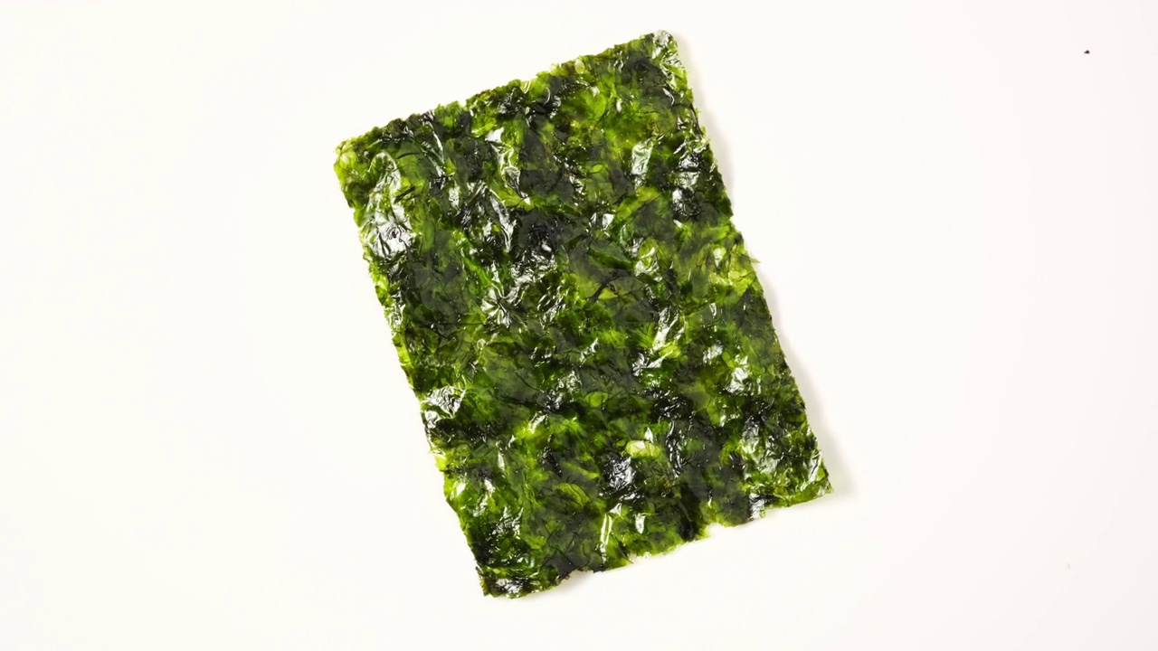 干海藻片，裙带菜。日本海带小吃。干的绿色可食用海带。方便半成品、加工食品。4K视频，旋转