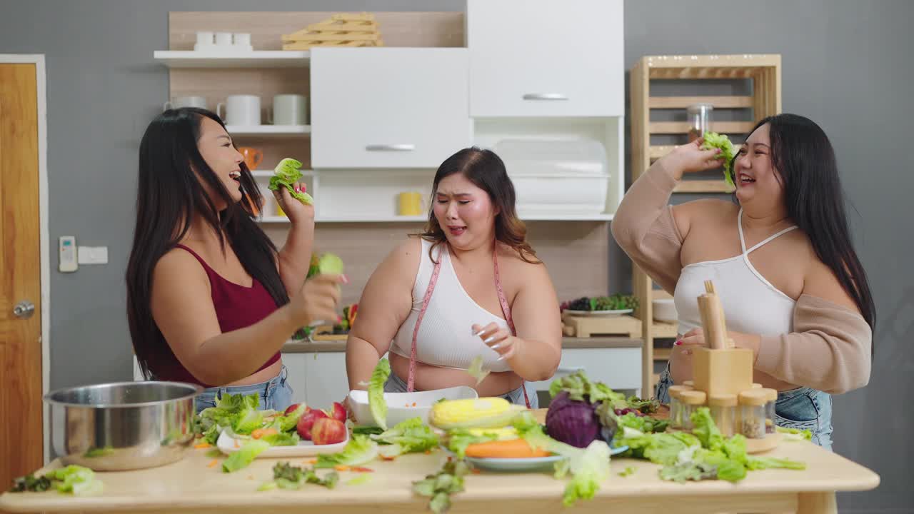 一群快乐的胖乎乎的女性朋友向空中扔蔬菜。三个亚洲大码女人把蔬菜扔向空中，对自己的身体很有信心。健康食物概念