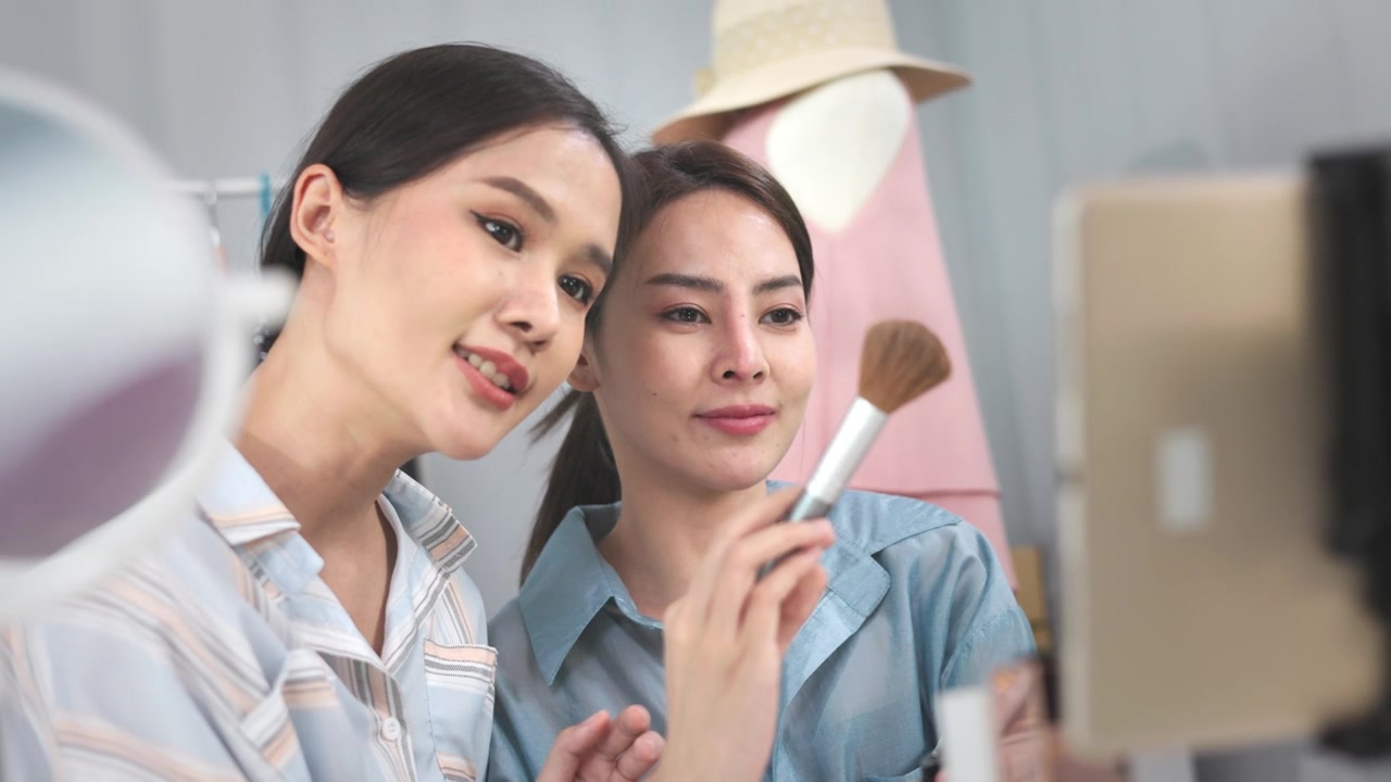詳情圖-亞洲女性企業(yè)主在時裝商店展示服裝，在智能手機(jī)前錄制視頻視頻直播，向顧客出售時裝，網(wǎng)上購物概念。