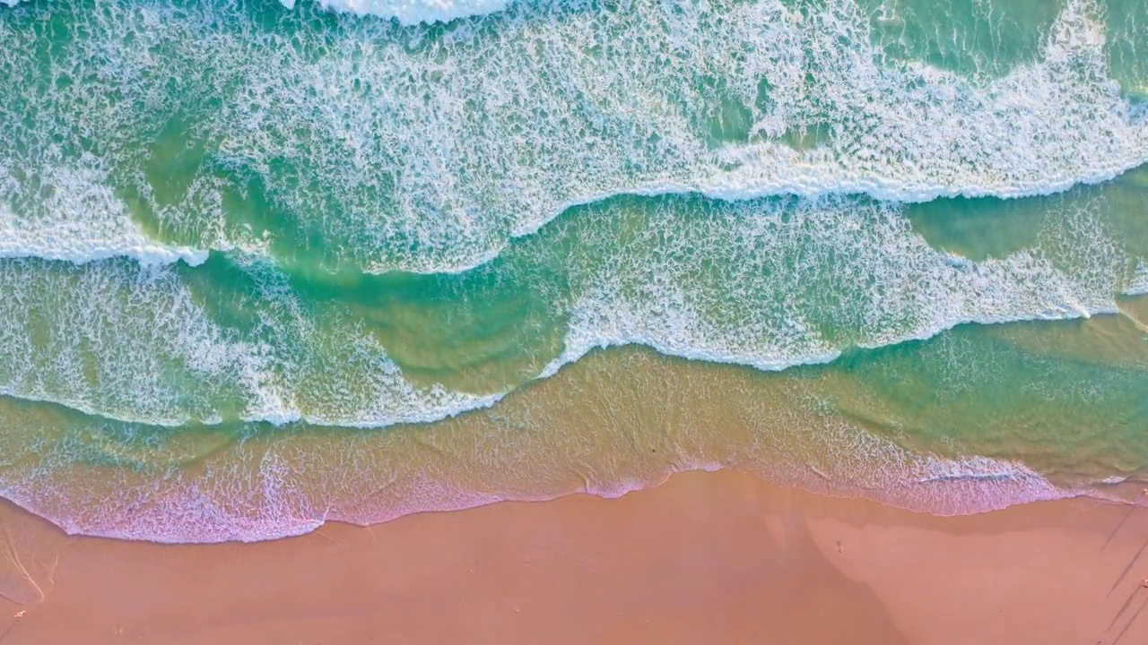 海浪海面高质量的视频鸟瞰，无人机顶视图海浪冲击沙滩，自然海洋海滩的背景