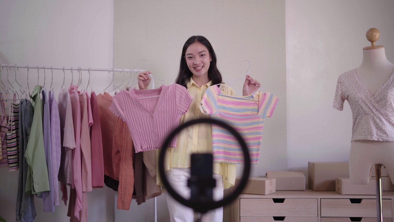 詳情圖-年輕的亞洲女士時裝展示二手服裝產(chǎn)品呈現(xiàn)細(xì)節(jié)錄制視頻直播在家辦公室創(chuàng)業(yè)小企業(yè)企業(yè)家中小企業(yè)電話營銷倉庫博客概念。
