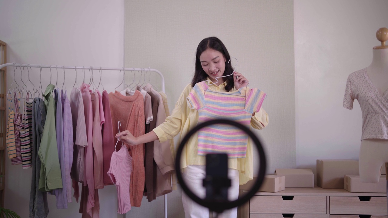 詳情圖-年輕的亞洲女士時裝展示二手服裝產(chǎn)品呈現(xiàn)細(xì)節(jié)錄制視頻直播在家辦公室創(chuàng)業(yè)小企業(yè)企業(yè)家中小企業(yè)電話營銷倉庫博客概念。