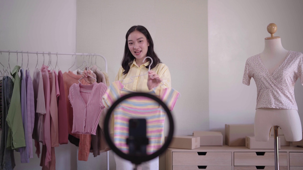 詳情圖-年輕的亞洲女士時裝展示二手服裝產(chǎn)品呈現(xiàn)細(xì)節(jié)錄制視頻直播在家辦公室創(chuàng)業(yè)小企業(yè)企業(yè)家中小企業(yè)電話營銷倉庫博客概念。