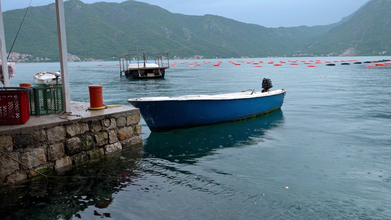 详情图-有马达的捕鱼木船在海上下雨时停泊在石码头。