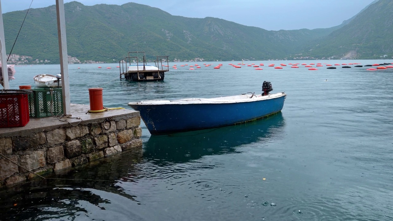 详情图-有马达的捕鱼木船在海上下雨时停泊在石码头。