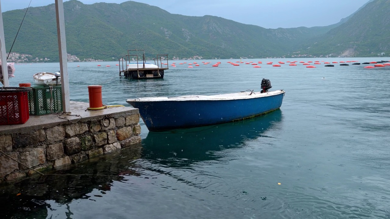 详情图-有马达的捕鱼木船在海上下雨时停泊在石码头。