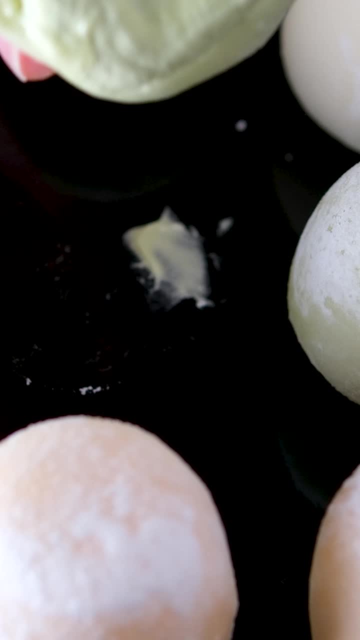 麻糬冰淇淋咬一口甜点，然后把它放回一个带有绿茶味的黑色盘子里，这是一种受欢迎的亚洲美食