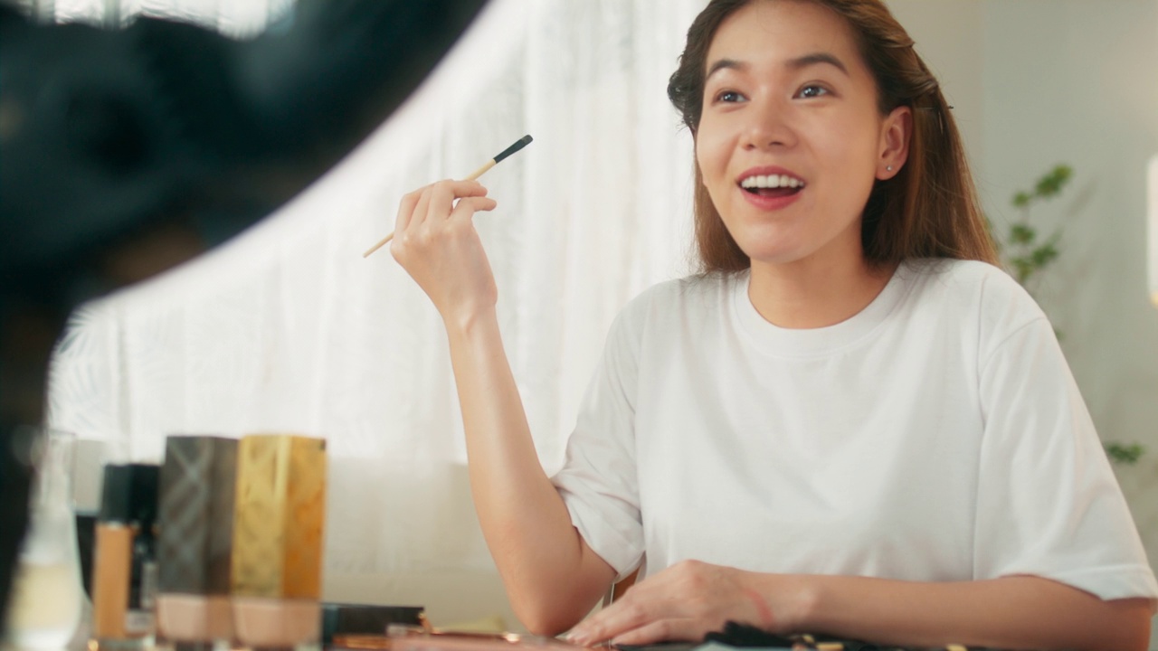 有吸引力的年輕亞洲女性網(wǎng)紅在移動應用程序上在線直播分享化妝技巧