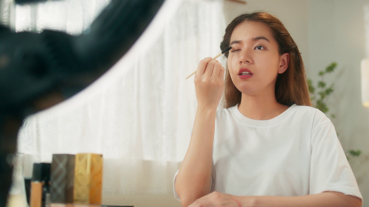 詳情圖-有吸引力的年輕亞洲女性網(wǎng)紅在移動應(yīng)用程序上在線直播分享化妝技巧