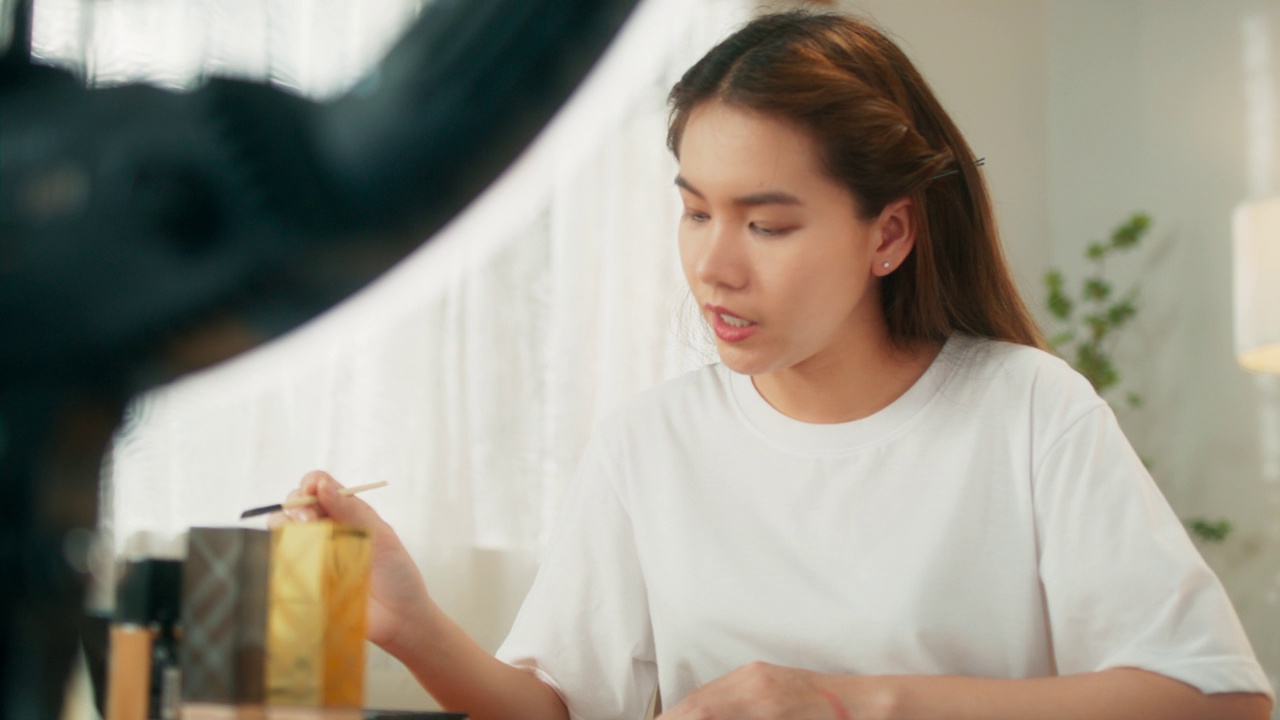 詳情圖-有吸引力的年輕亞洲女性網(wǎng)紅在移動應(yīng)用程序上在線直播分享化妝技巧