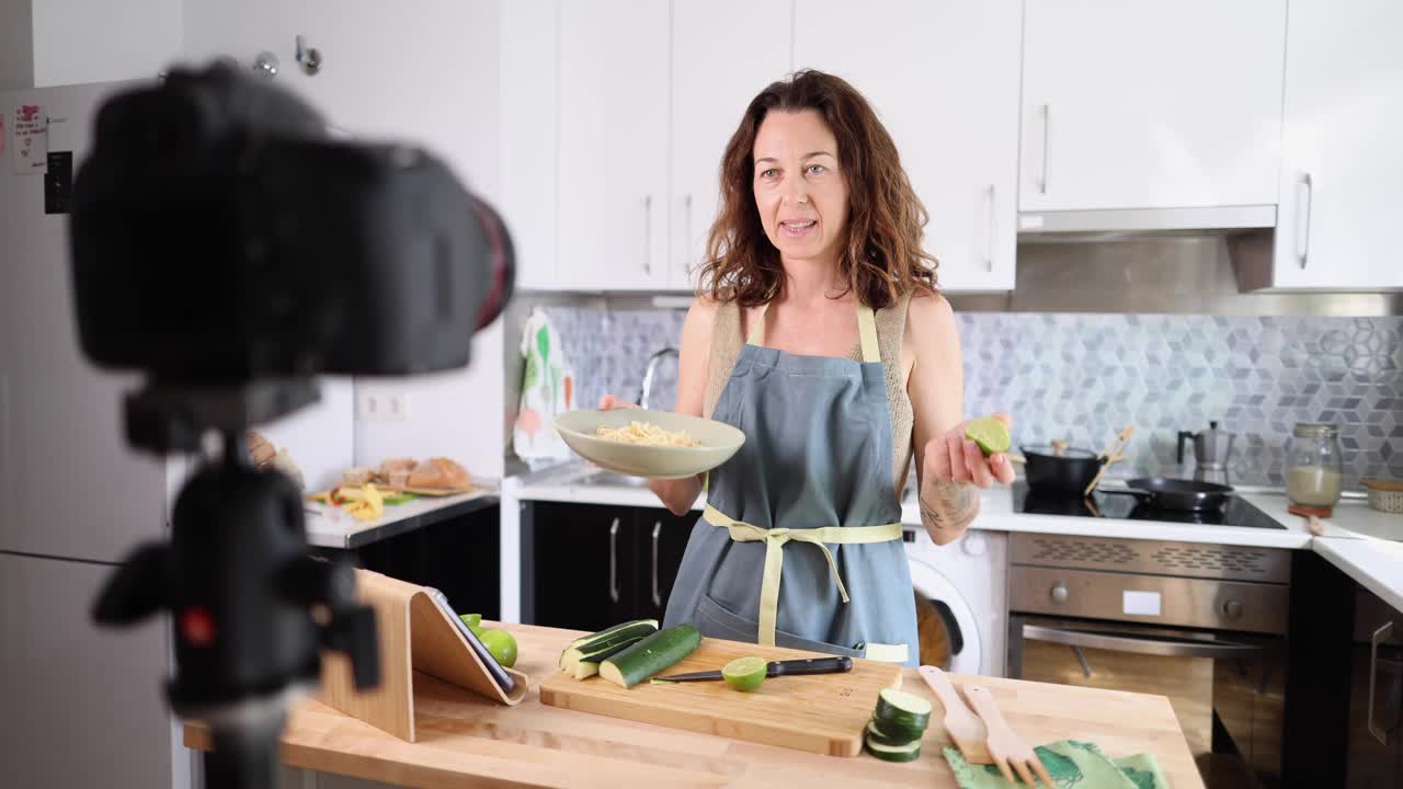 一名成年女性在为她的健康食品博客做饭时用相机记录自己