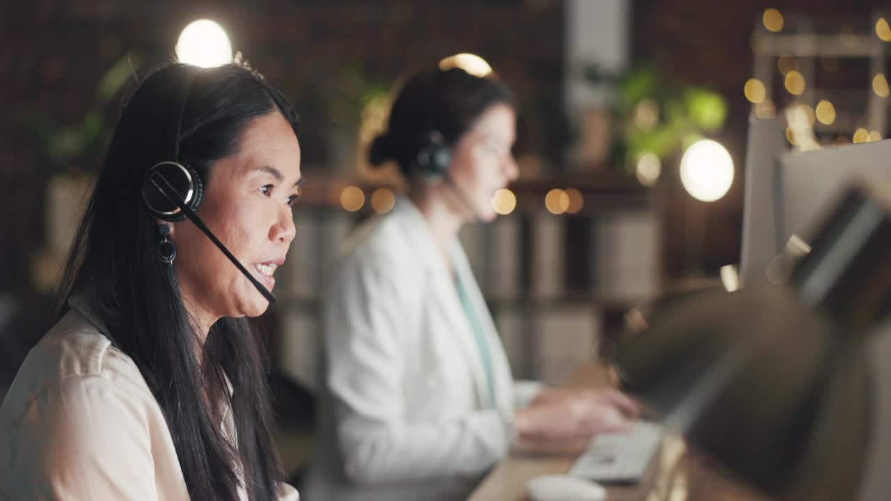 呼叫中心计算机，咨询或亚洲女性解释电信，客户服务或通信。在客户关系管理办公室或技术支持办公室的电脑或成熟代理麦克风耳机