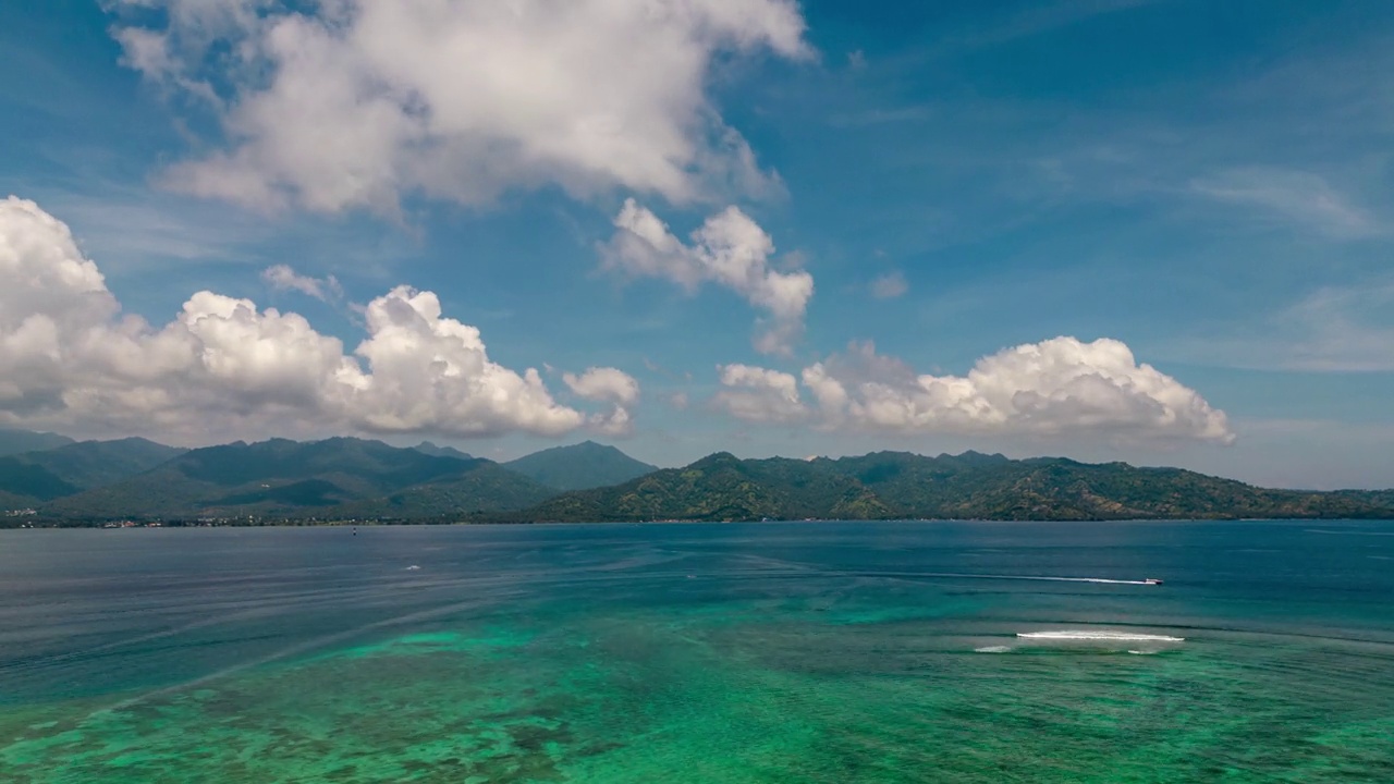 美丽的海洋和岛屿与云在地平线上的时间推移。热带旅游目的地飞行超延时。海滩和云景在晴天。蓝色背景上的丛林树木。海上景观