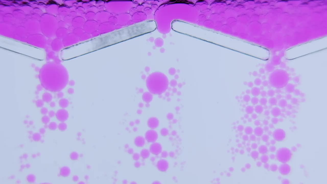 微观世界中的液体气泡。清澈的液体从三个孔中倾泻而下。