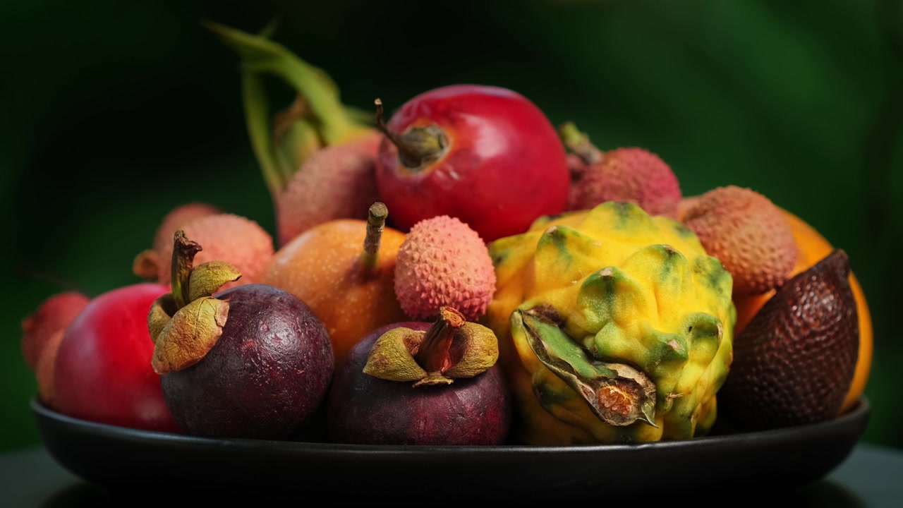 详情图-在绿色背景上旋转异国水果(百香果，柽柳，荔枝，Pitahaya,,Salak,,Granadilla，山竹)