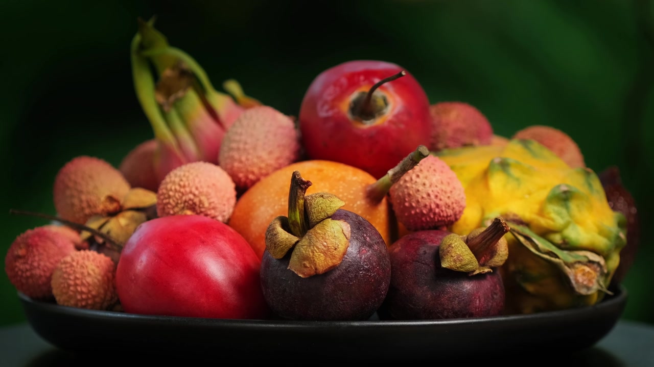 详情图-在绿色背景上旋转异国水果(百香果，柽柳，荔枝，Pitahaya,,Salak,,Granadilla，山竹)