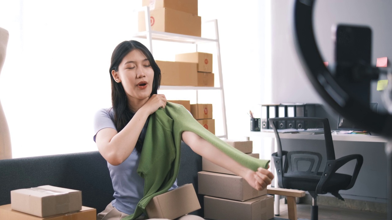 詳情圖-熱情的亞洲企業(yè)主，服裝或布料在線商店與她的客戶在線互動，直播以吸引更多的客戶關(guān)注。