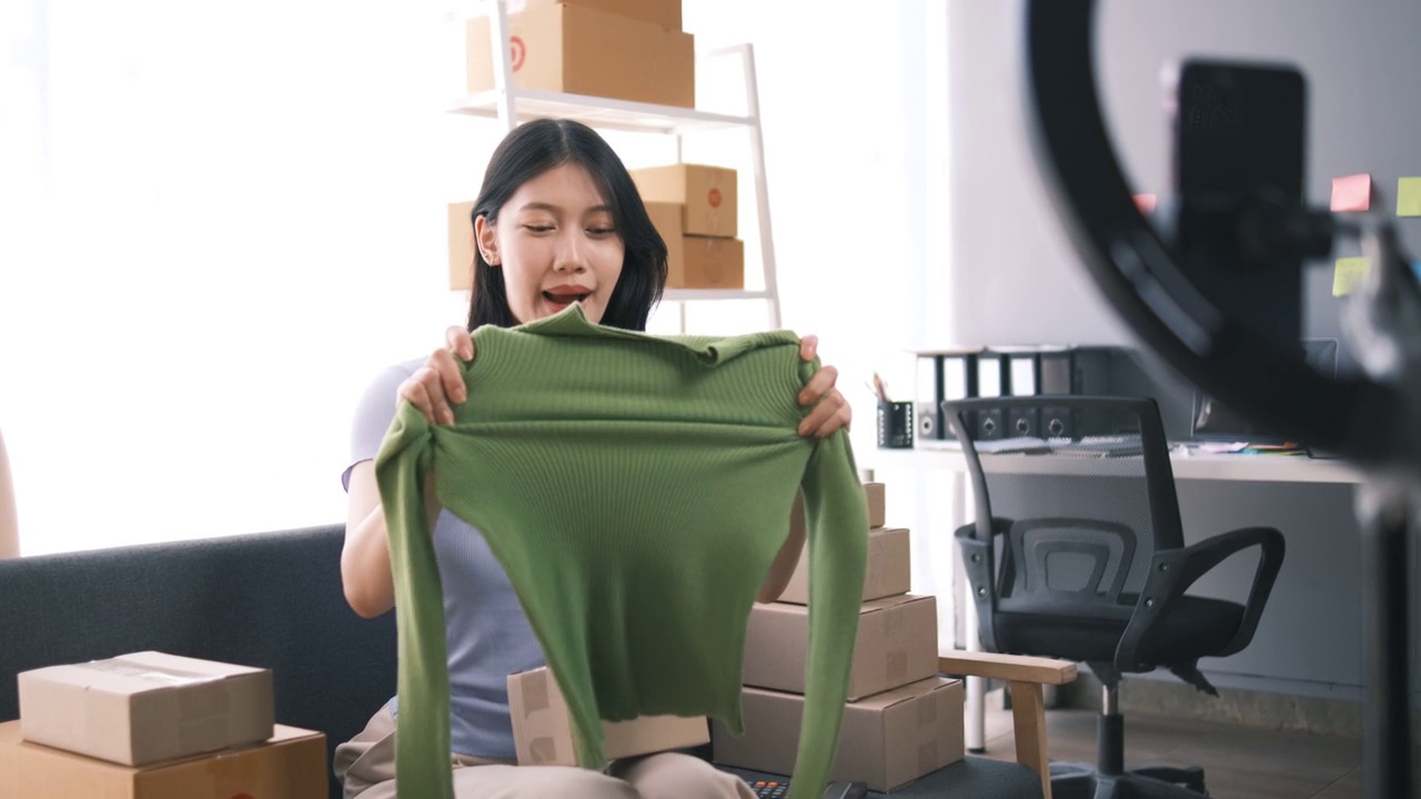 詳情圖-熱情的亞洲企業(yè)主，服裝或布料在線商店與她的客戶在線互動，直播以吸引更多的客戶關(guān)注。