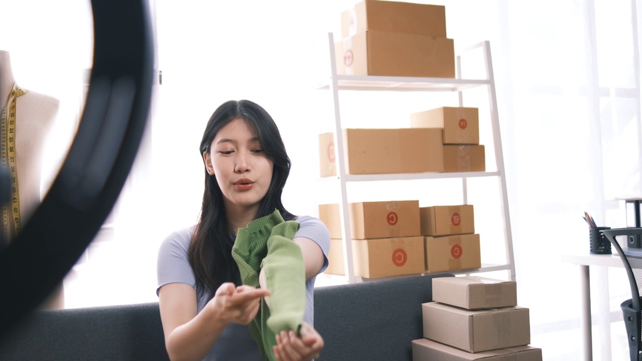 詳情圖-熱情的亞洲企業(yè)主，服裝或布料在線(xiàn)商店與她的客戶(hù)在線(xiàn)互動(dòng)，直播以吸引更多的客戶(hù)關(guān)注。