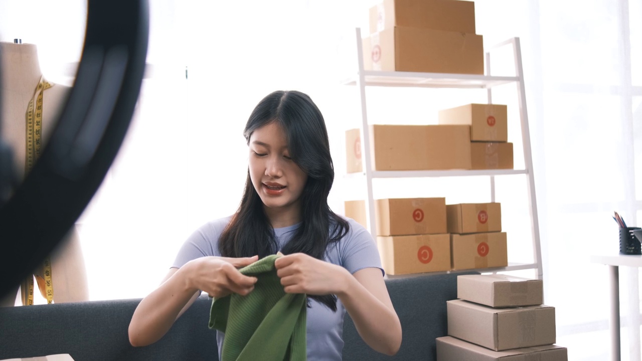 詳情圖-熱情的亞洲企業(yè)主，服裝或布料在線(xiàn)商店與她的客戶(hù)在線(xiàn)互動(dòng)，直播以吸引更多的客戶(hù)關(guān)注。