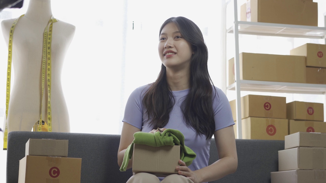 详情图-亚洲女孩在公寓用笔记本电脑在网上卖衣服，时尚博主在网上博客录视频，可爱的女人在家里的网上服装店直播