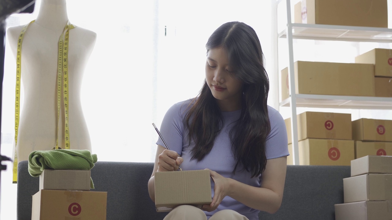 详情图-亚洲女孩在公寓用笔记本电脑在网上卖衣服，时尚博主在网上博客录视频，可爱的女人在家里的网上服装店直播