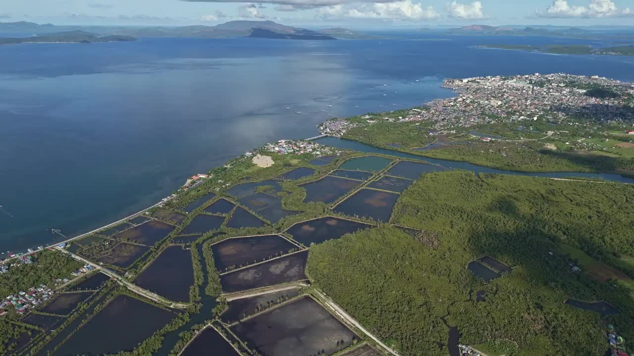 令人印象深刻的苏里高海峡无人机拍摄，有大量的水产养殖鱼塘和郁郁葱葱的低地。白天。