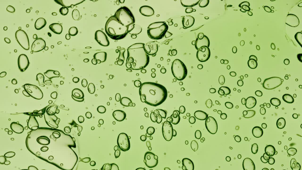 透明化妆品凝胶流体与分子气泡和油分布在白色背景。天然有机化妆品、药品微距拍摄。生产特写。缓慢的运动。