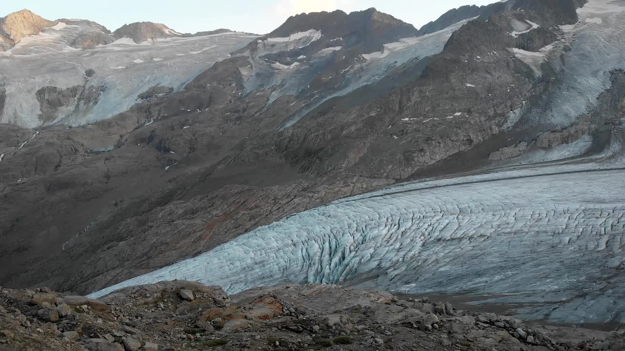 在瑞士阿尔卑斯山伯尔尼高地地区的高利冰川附近的空中飞行，在日落时俯瞰冰川的裂缝。