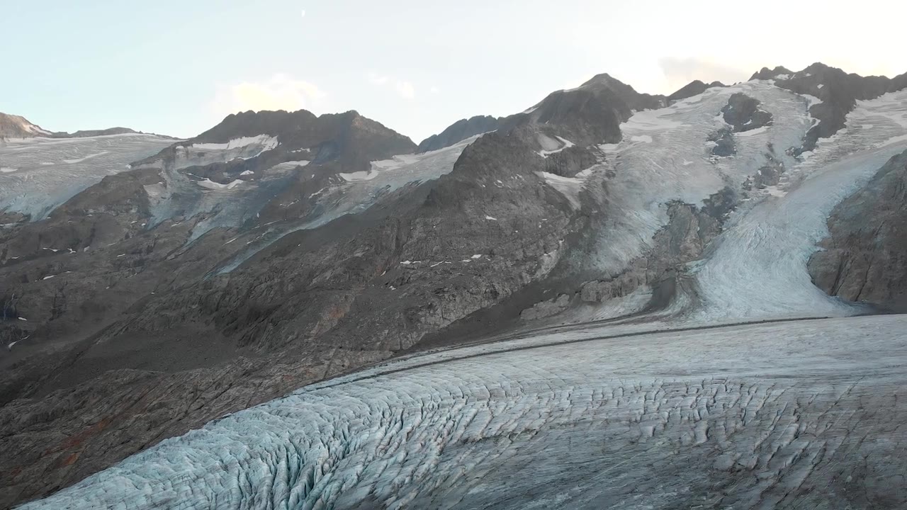 详情图-在瑞士阿尔卑斯山伯尔尼高地地区的高利冰川附近的空中飞行，在日落时俯瞰冰川的裂缝。