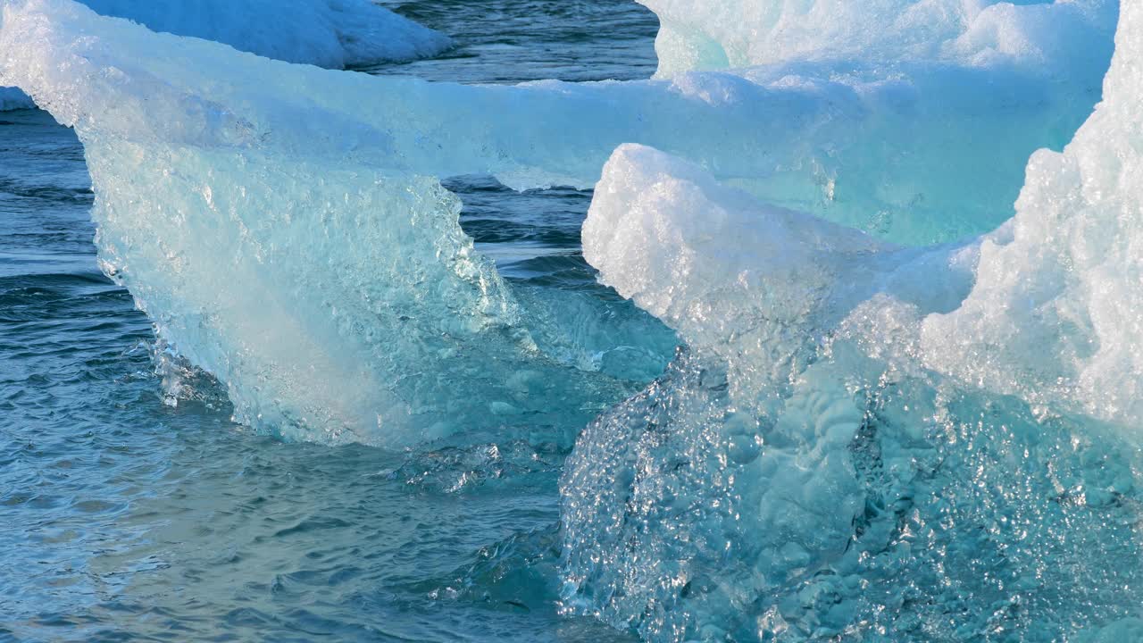 蓝色冰山在咸水中漂流，冰岛的Jokulsarlon冰川泻湖，冰川融化产生的纯蓝色冰