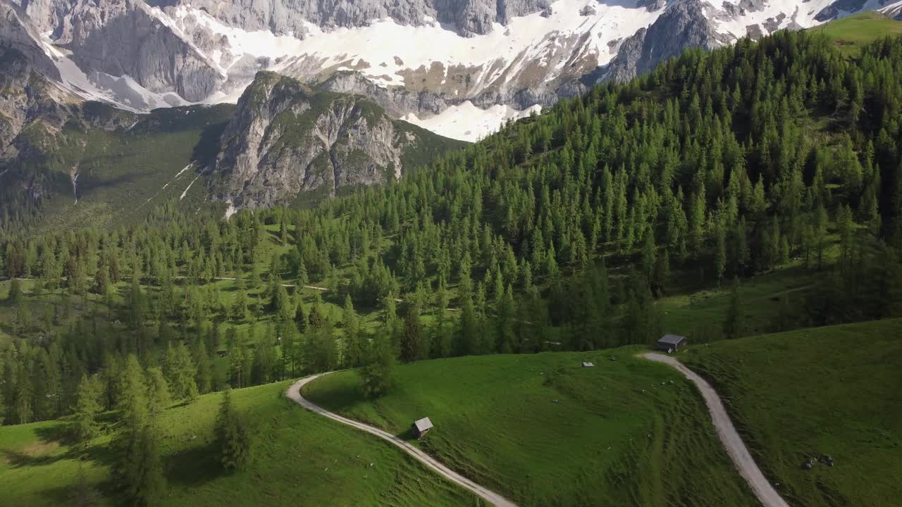 4K无人机拍摄的雄伟的达赫施泰因冰川，施蒂里亚，奥地利在阿尔卑斯山。高山滑雪和越野滑雪、单板滑雪的热门地区。巨大的岩层俯瞰着郁郁葱葱的绿色田野。