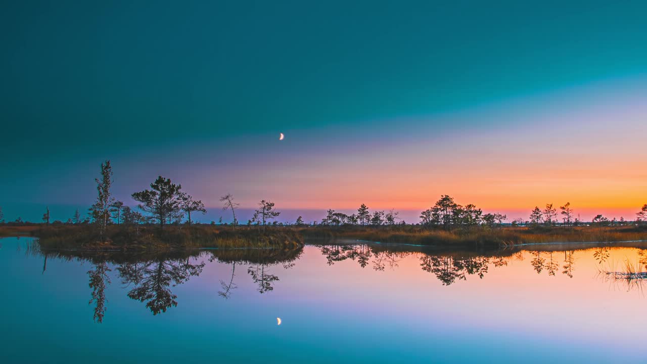 平静的湖水，水中的星光反射。4K银河星星从水面升起。景观与湖泊沼泽沼泽湿地自然在夜间灯光。延时星空银河系与发光的星星