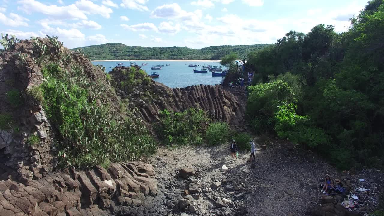 越南富延地区玄武岩互锁柱Ghenh Da Dia的Flycam渔船和山的背景