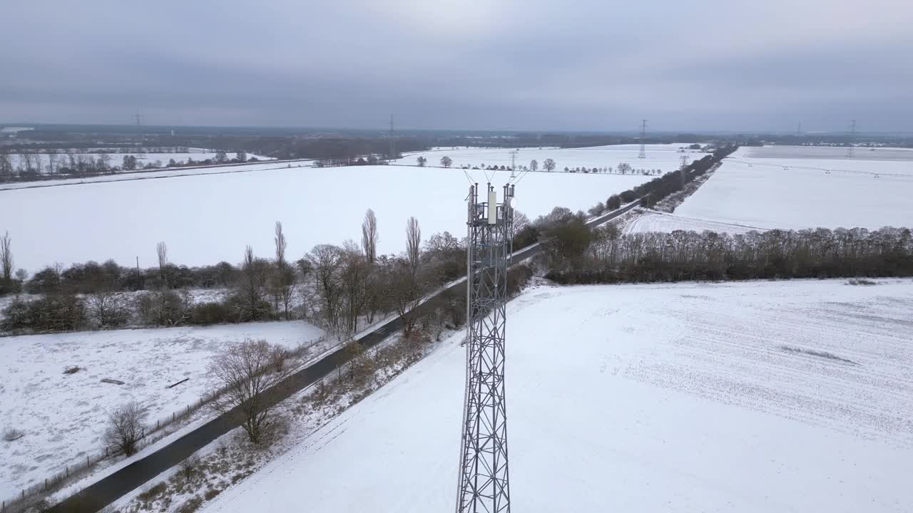 村蜂窝塔移动5G基站传输电话，冬雪。魔术空中俯视飞行全景轨道无人机4 k的片段