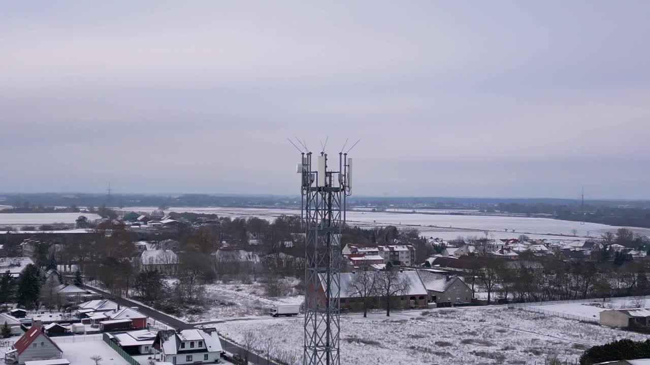 手机塔移动5G桅杆传输电话，冬雪。戏剧性的空中俯视图飞行圈无人机镜头4 k的片段