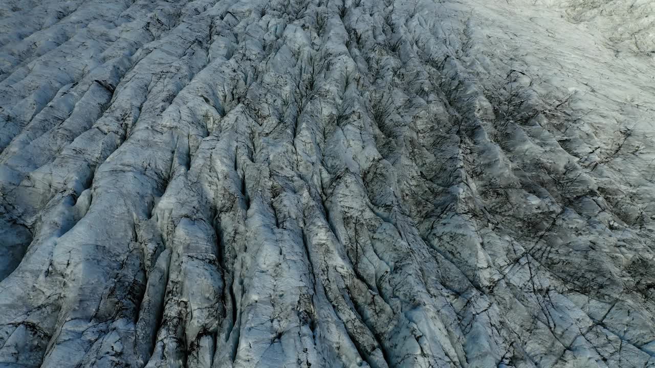 黎明时分，在瑞士恩加丁的morteratsch冰川上空，一架平底飞机朝着冰川末端和被雾覆盖的山谷上空飞行