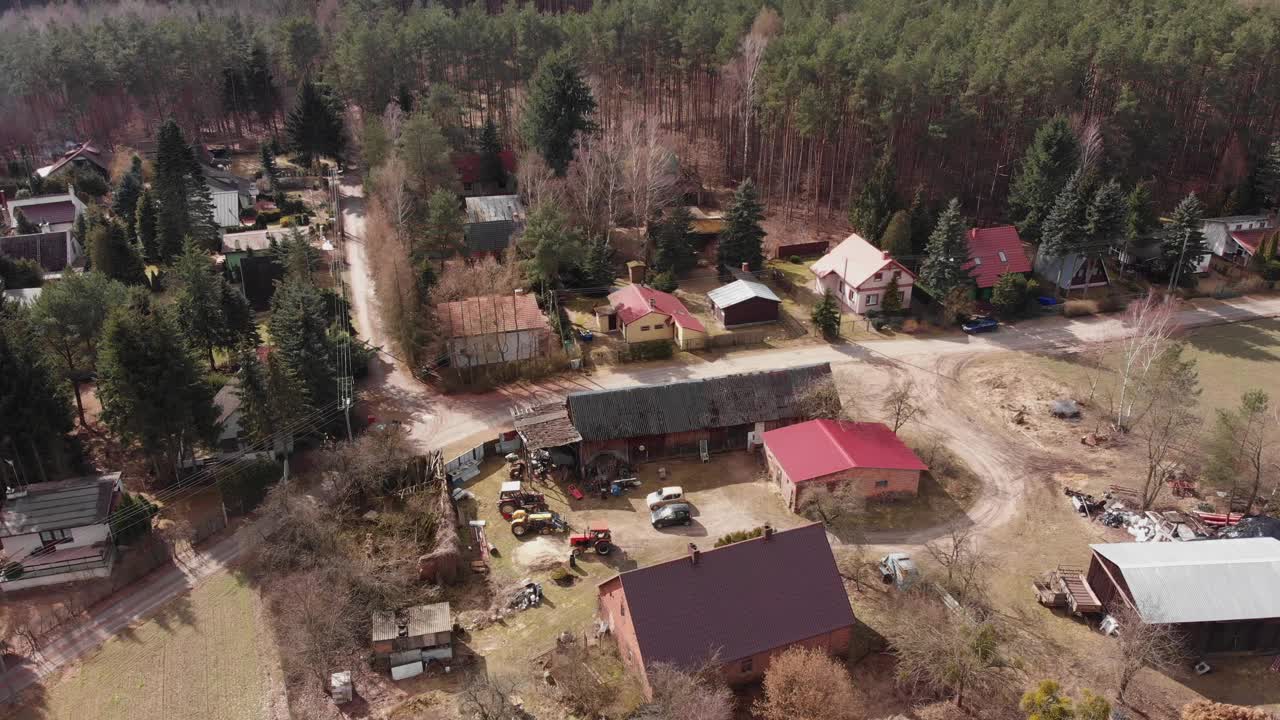 农用拖拉机在农村波兰村庄的木制建筑外的边缘