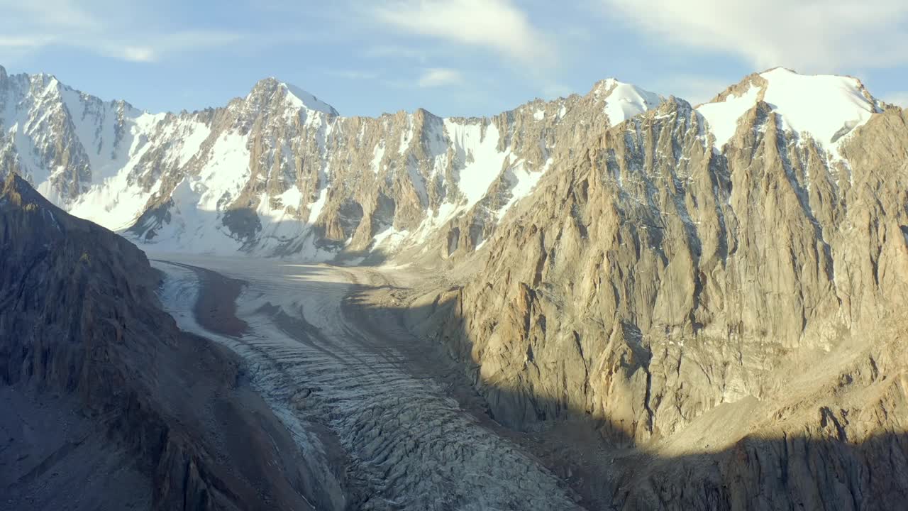 从阿克赛冰川的高处俯瞰。风景如画的山景。吉尔吉斯斯坦美丽的雪山、山脊、丘陵和岩石。