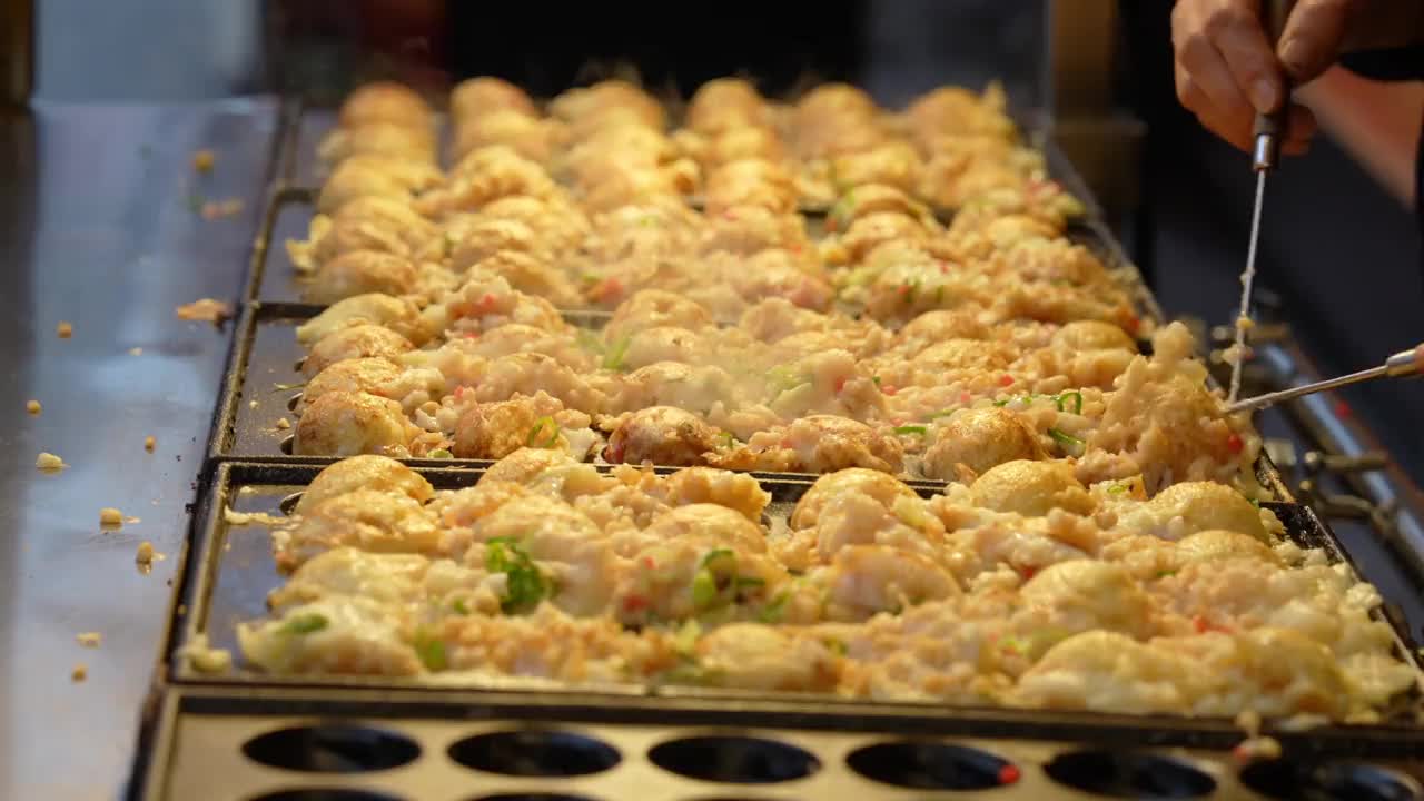 在小吃摊上烤章鱼烧的视频