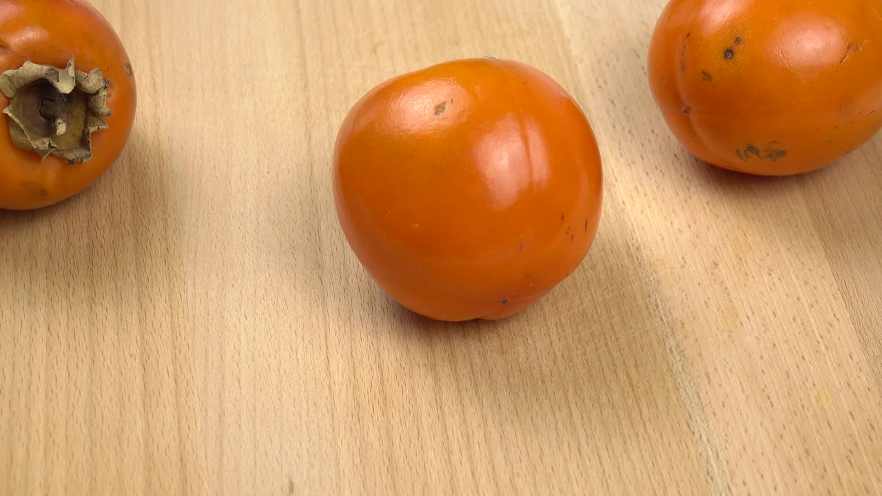 新鲜的柿子正在砧板上切成小块