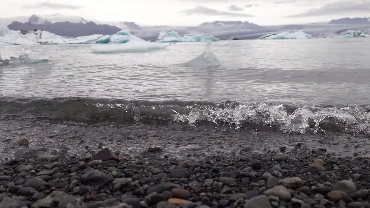 冰岛Jokulsarlon冰川泻湖的低角度视图。寒潮冲刷着海湾的海岸