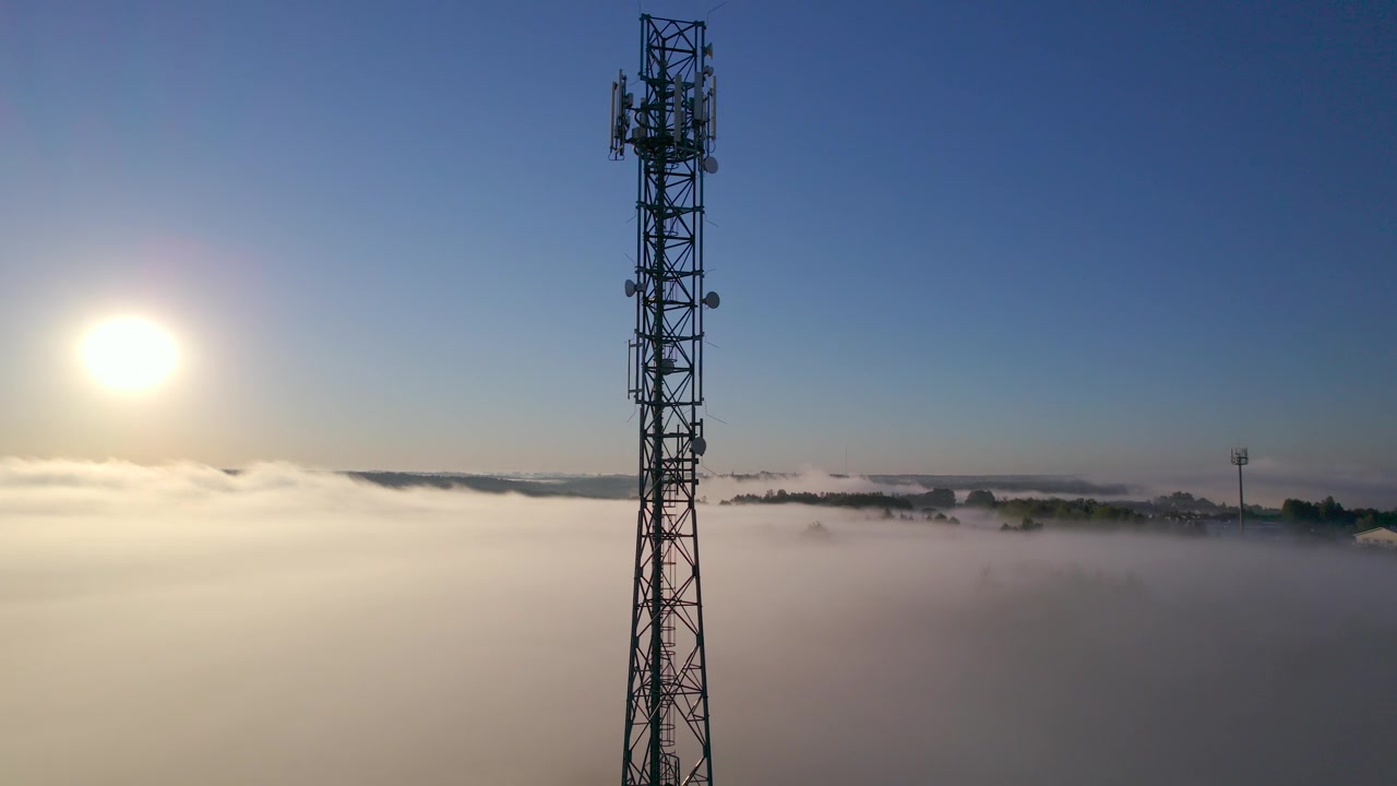 详情图-塔式天线电信手机鸟瞰图，蜂窝5g,4g手机无线电发射机。提供高速现代5g通信网服务。日出时的云雾和天空