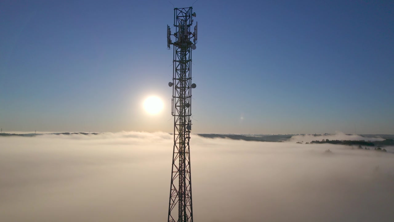 详情图-塔式天线电信手机鸟瞰图，蜂窝5g,4g手机无线电发射机。提供高速现代5g通信网服务。日出时的云雾和天空