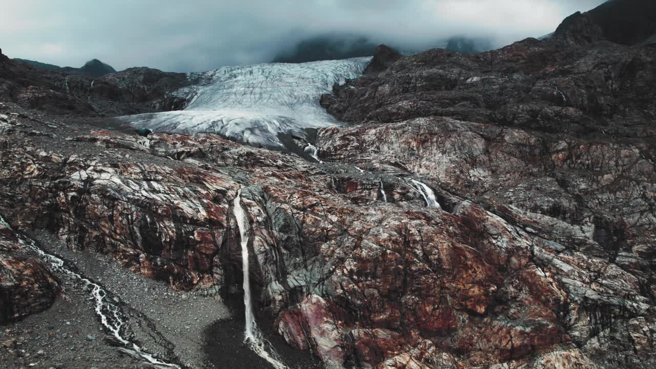 融化的冰川与瀑布在意大利阿尔卑斯山，航拍全景景观