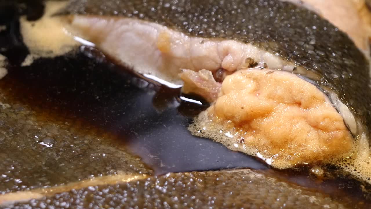 生比目鱼片在肉汤中煨煮的特写视频。里面有个蛋的比目鱼。