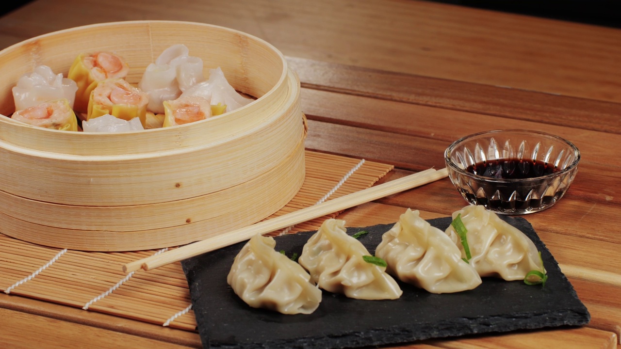 詳情圖-桌子上各種點(diǎn)心和餃子特寫宏觀。中國(guó)和日本的食物。點(diǎn)心配蝦、魚和肉。加肉、牛肉和蔬菜的格薩。咖啡館里的菜肴。自制的。交付