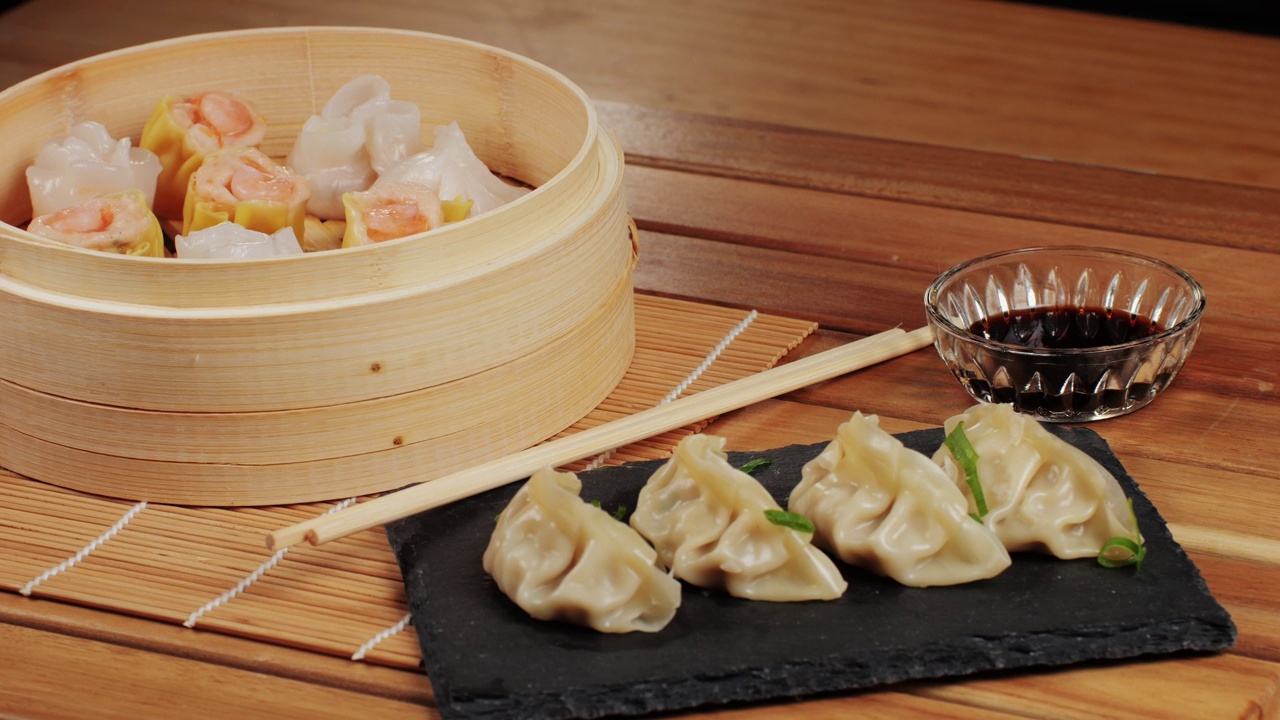 詳情圖-桌子上各種點(diǎn)心和餃子特寫宏觀。中國(guó)和日本的食物。點(diǎn)心配蝦、魚和肉。加肉、牛肉和蔬菜的格薩。咖啡館里的菜肴。自制的。交付