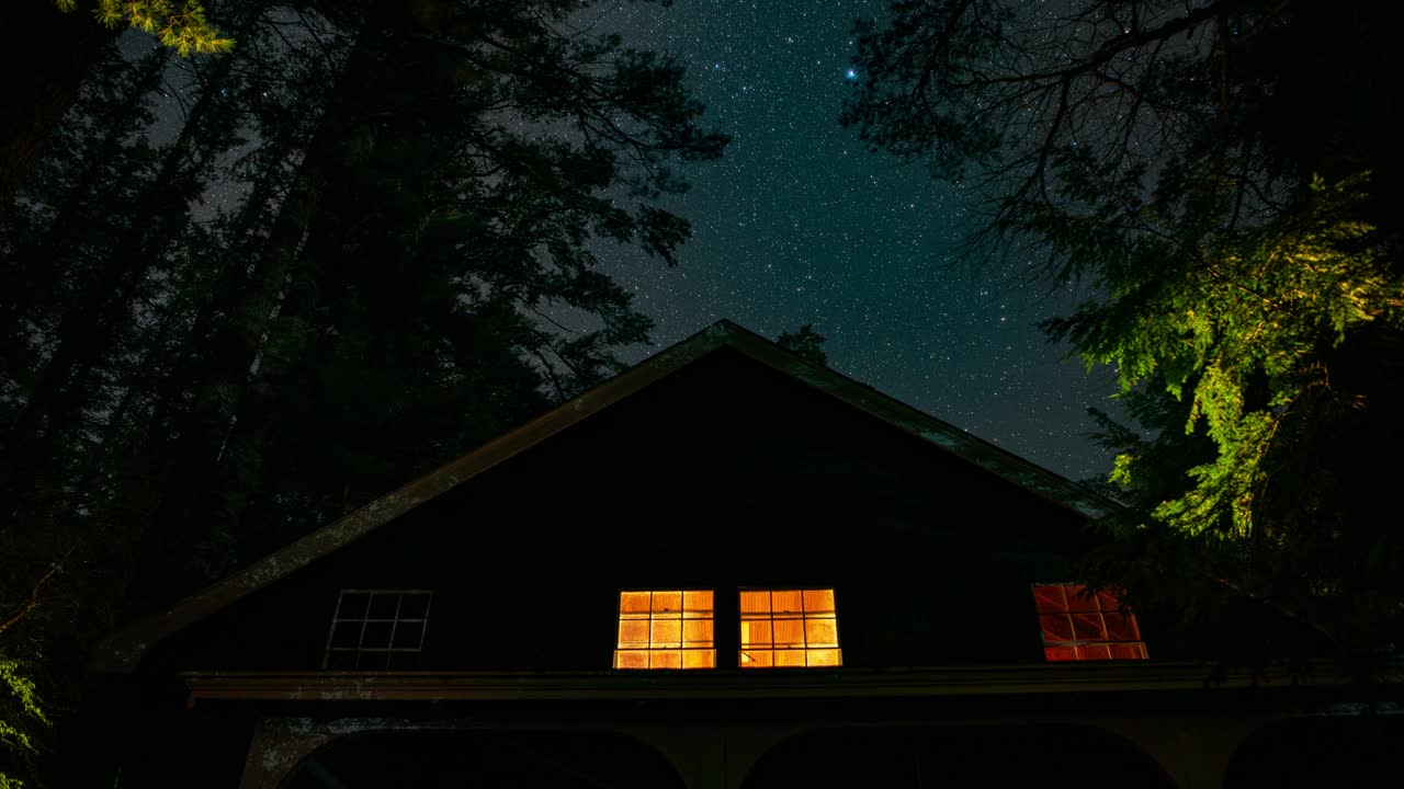 夏夜，在新英格兰的树林里，一间质朴舒适的小屋后面，星星的时间流逝，银河在薄云后面清晰可见